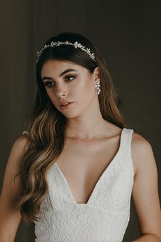 a woman wearing a wedding dress with a tiara on her head and hair comb