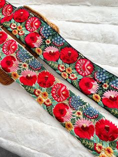 two pieces of fabric with flowers on them sitting next to each other in front of a basket