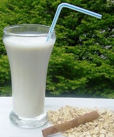 a glass with a straw and some oats on a table