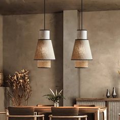 a dining room table with chairs and lamps hanging from the ceiling