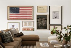 a living room filled with furniture and framed pictures on the wall above it's coffee table