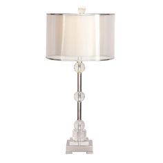 a glass table lamp with a white shade on the base and a silver metal base