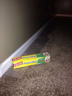 two boxes of glad toothpaste sitting on the floor next to a door way