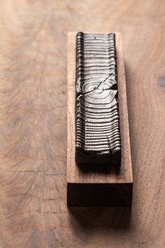 a piece of wood that is on top of a wooden table with some sort of object in it