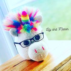 a crocheted stuffed animal with glasses on it's head and rainbow hair