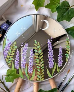 a mirror with purple flowers painted on it