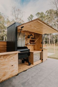 an outdoor kitchen made out of plywood and wood with shelves on the outside wall