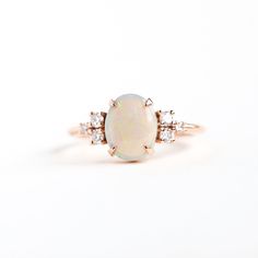 an opal and diamond ring on a white background