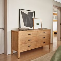 a wooden dresser with pictures on top of it