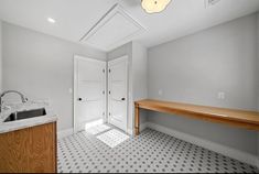 an empty room with a sink and counter top next to a door that leads to another room