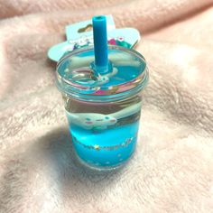 a blue liquid in a small glass with a toothbrush sticking out of the top