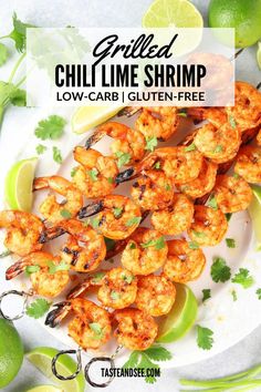 grilled shrimp on a plate with limes and cilantro garnish