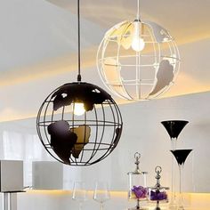 three globes hanging from the ceiling in a room with white walls and flooring