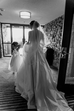 the bride is getting ready to walk down the aisle with her flower girl in tow