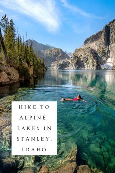 a person swimming in the water with mountains and trees behind them that says hike to alpine lakes in stanley, idaho