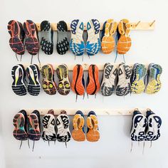 there are many pairs of shoes hanging on the wall next to each other in different colors