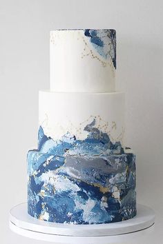 a three tiered cake with blue and white designs