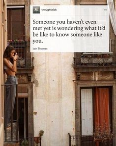 a woman standing on a balcony talking on her cell phone