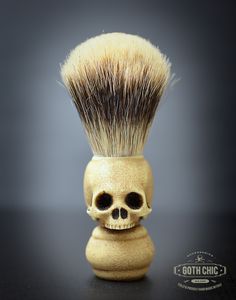 a skull shaped shaving brush with a black background