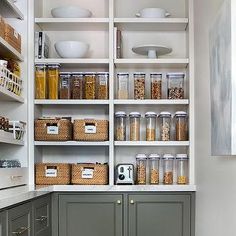 an organized pantry with gray cabinets and white walls, filled with food items such as cereals