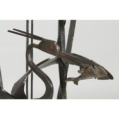 a metal sculpture that looks like it has scissors stuck in it's claws and is hanging from the side