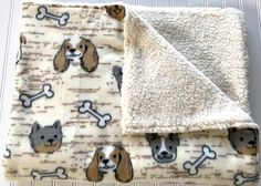 a blanket with dogs and bones on it is laying next to a dog bone pattern