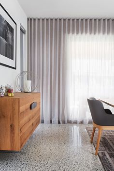 a dining room table with two chairs in front of it and a large window behind it