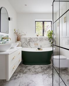 a bathroom with marble flooring and green bathtub next to a white counter top