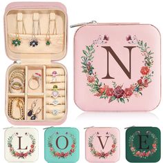 an open pink case filled with jewelry on top of a white table next to other items