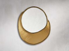 a mirror that is on the wall with a gold frame and round mirror above it