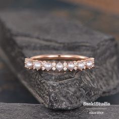 an image of a wedding band with pearls on it's sides and diamonds in the middle