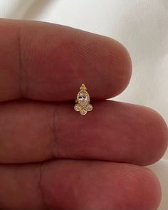 a person's hand holding a yellow and white diamond ring