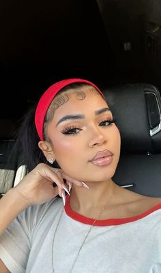 a woman sitting in the back seat of a car wearing a red headband