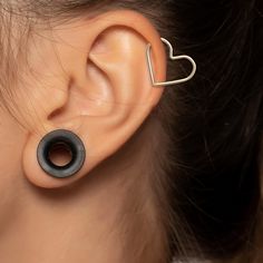 a close up of a person's ear with an earring in the shape of a heart