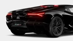 the rear end of a black sports car with red lights on it's side