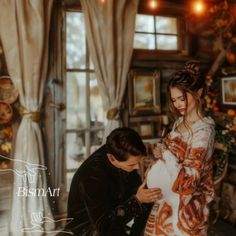 a man kneeling down next to a woman holding a baby