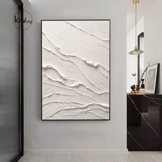 a white abstract painting hangs on the wall in a modern style bathroom with marble flooring