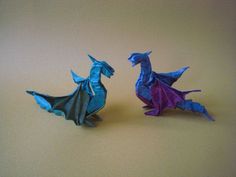 two origami dragon figurines sitting next to each other