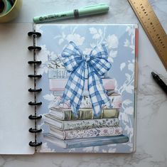 a notebook with a bow on top of books