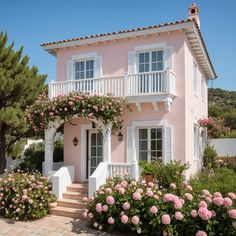 a pink house with white balconies and flowers