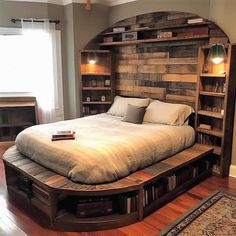 a large bed sitting inside of a bedroom next to a wooden book shelf on top of a hard wood floor