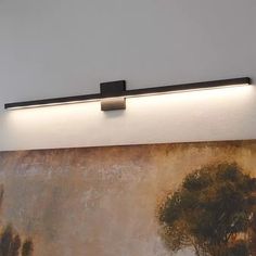 a wall light that is on above a painting