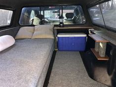 the inside of a camper with two couches and a cooler in it's back