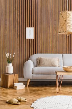 a living room with wood paneling and white furniture