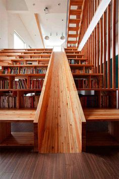 the stairs are made out of wood and have bookshelves on each side in front of them