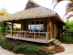 a house with a thatched roof and wooden deck