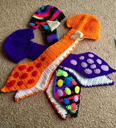 several knitted items laid out on the floor