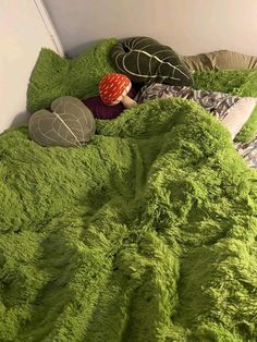 there is a green bed with two pillows and a stuffed turtle on top of it