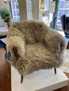 a chair made out of sheepskin on top of a white platform in a room