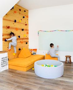 two children are climbing up the wall in their playroom